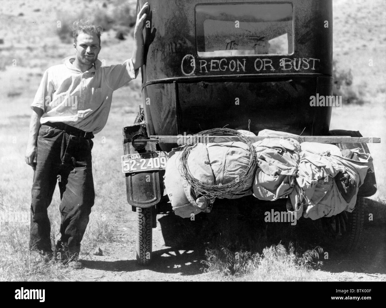 La depressione. Vernon Evans (con la sua famiglia e il suo modello T Ford, nei pressi di Missoula, Montana sulla Highway 10. Lasciando grasshopper-ridden e colpita dalla siccità Dakota del Sud per un nuovo inizio in Oregon. Foto di Arthur Rothstein, luglio 1936. Foto Stock