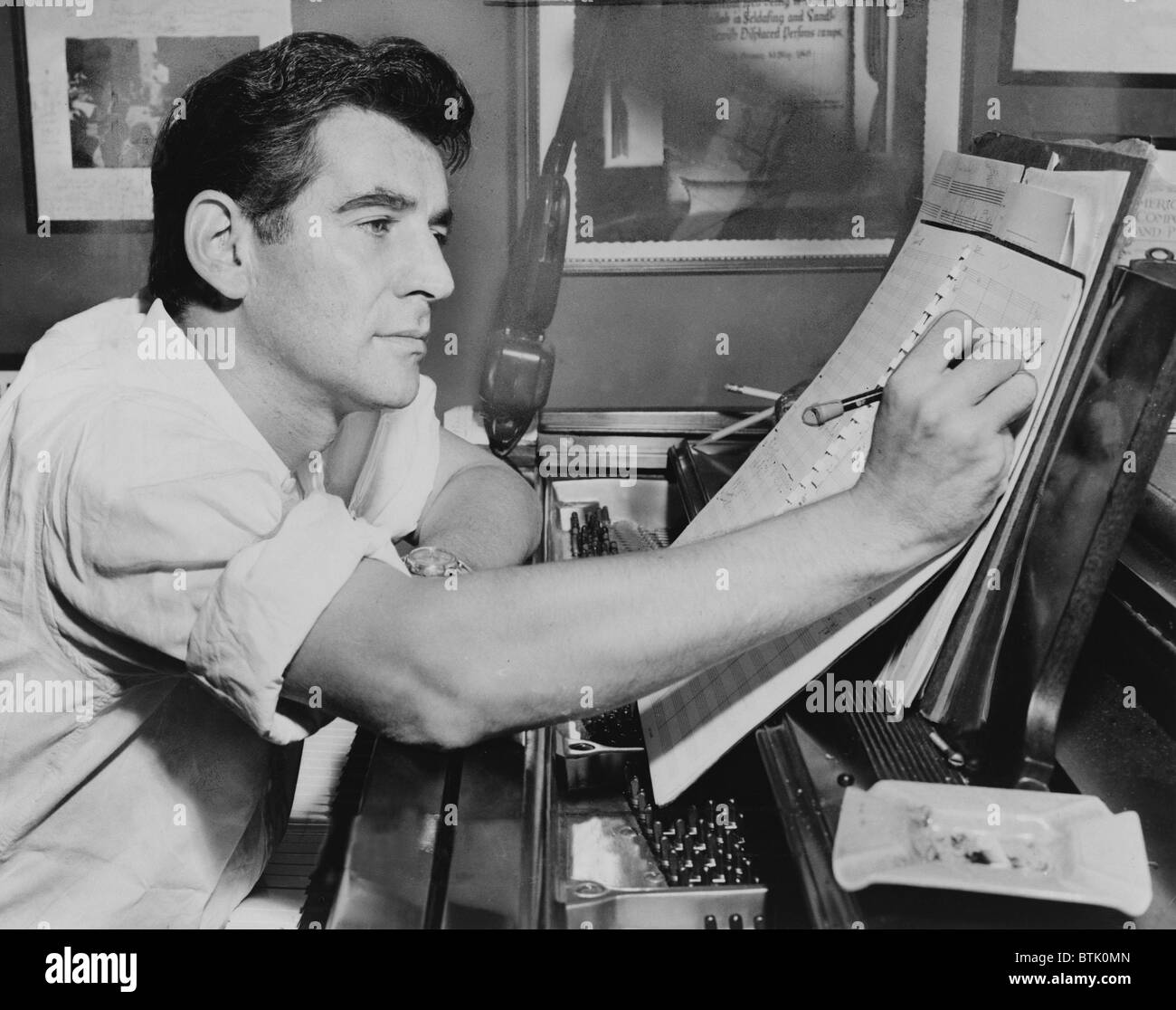 Leonard Bernstein (1918-1990), seduto al pianoforte, fare annotazioni di spartito musicale nel 1955. Bernstein composto punteggio per due musical di Broadway, CANDIDE (1956), e West Side Story (1957). Foto Stock