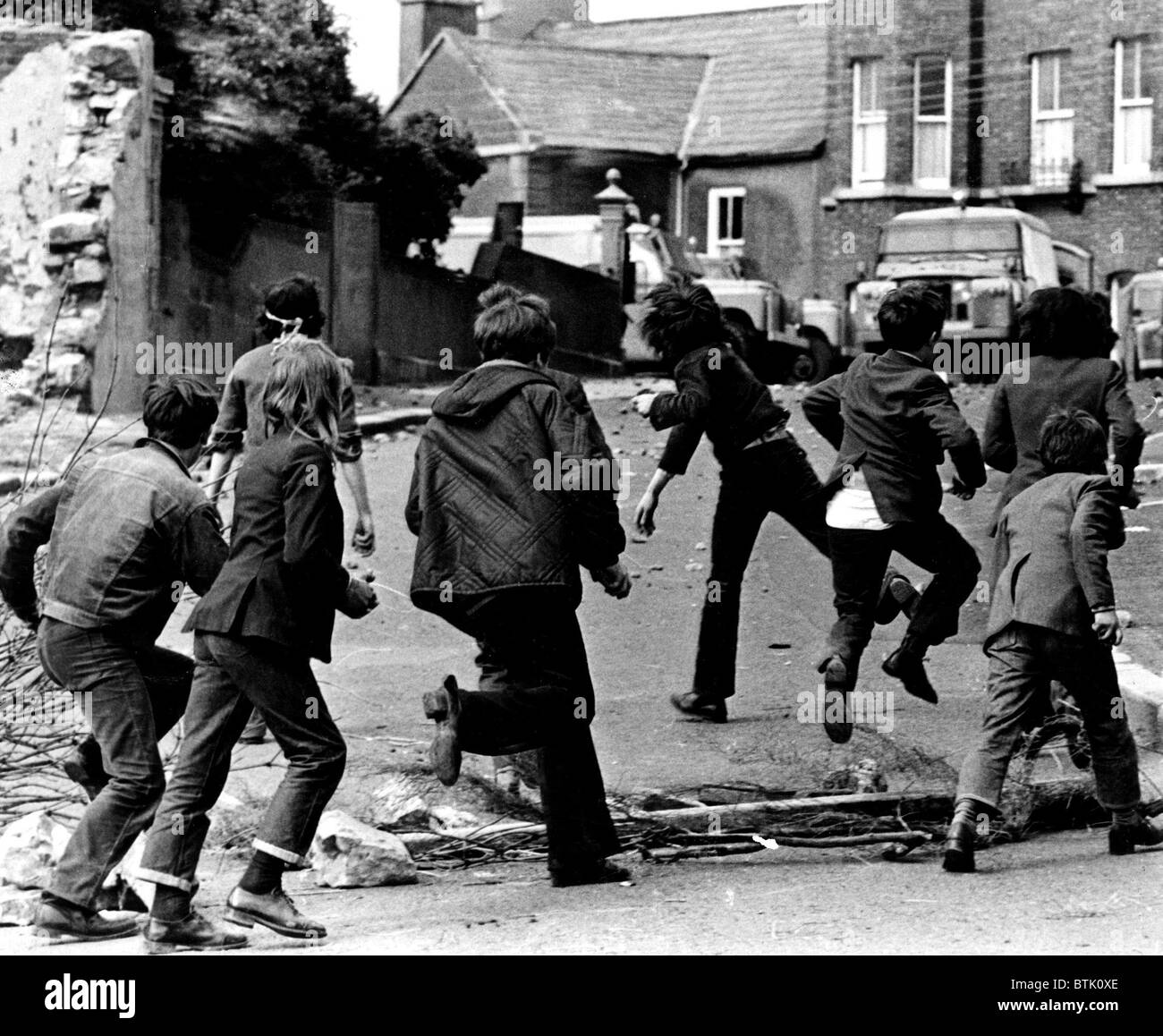 Bambini irlandesi gettando le rocce in un British portavalori a Armagh, Irlanda del Nord, 1972 Foto Stock