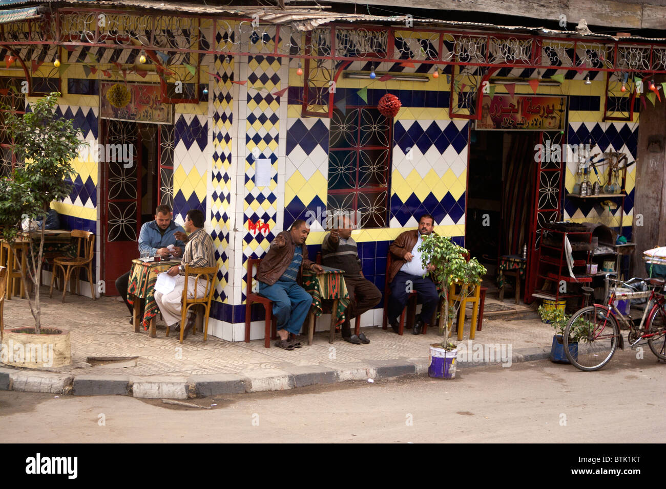 Uomini egiziano al di fuori di una coffeehouse in Alessandria, Egitto. Foto Stock
