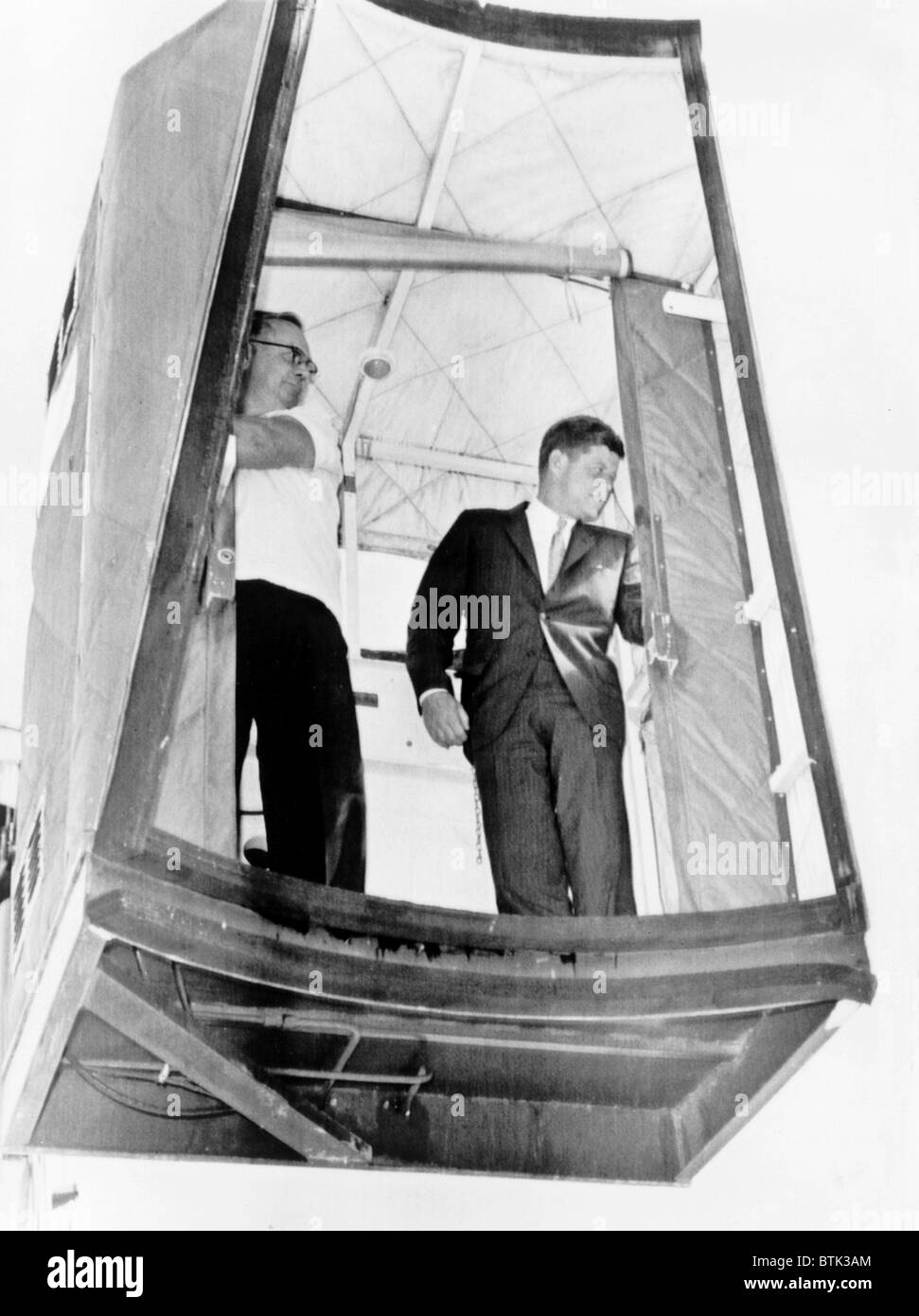 Il presidente John F. Kennedy a cavallo di un ascensore, chiamato un cherry picker, a bordo di aereo da West Palm Beach, Fla. torna a Washington D.C. Kennedy problemi alla schiena sono stati più gravi di pubblicamente ammesso. Giugno 1961. Foto Stock