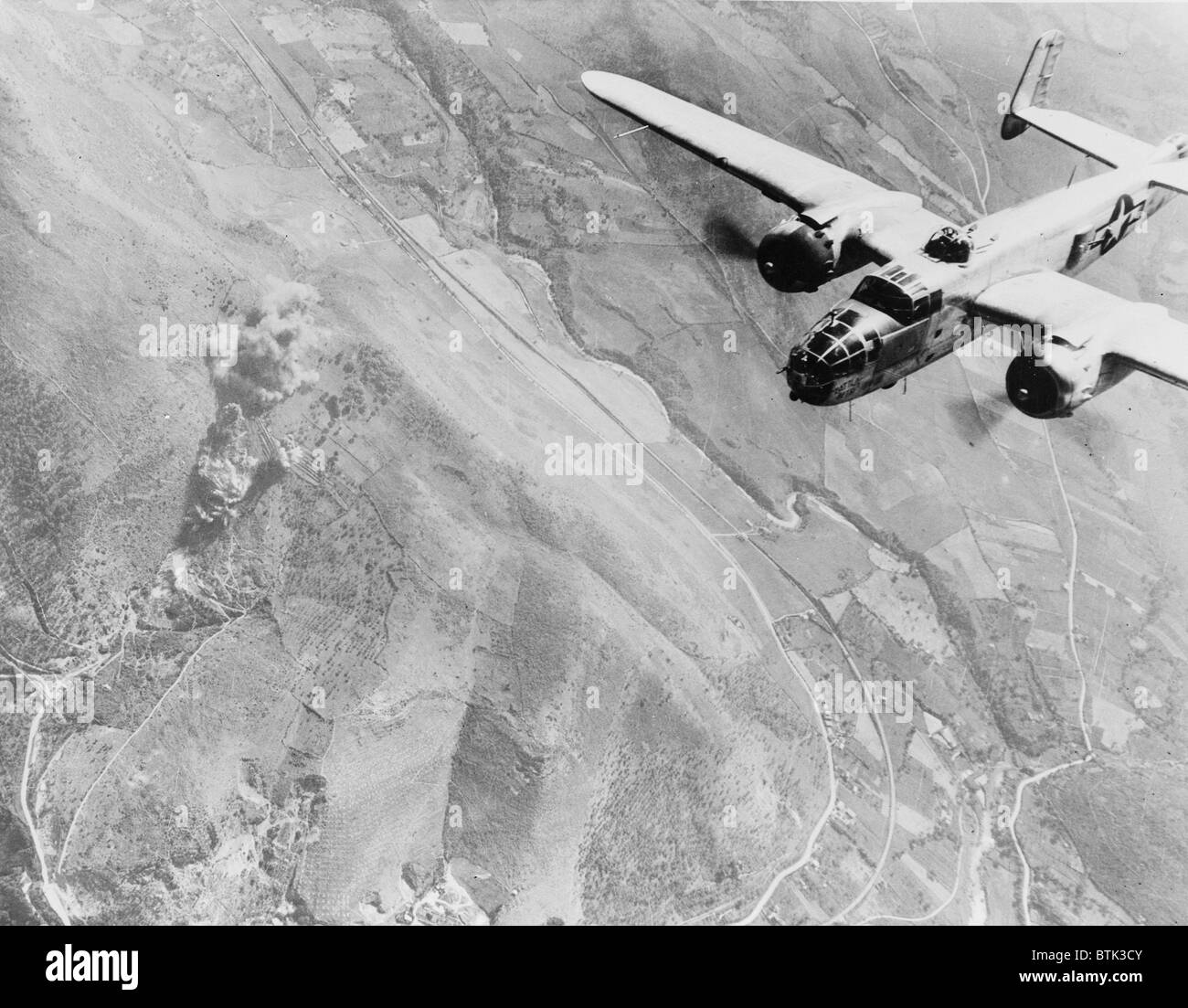 La II Guerra Mondiale, un nazista dump di alimentazione va in fumo. Un U.S. B-25 bombardiere medio ruggisce su Tivoli nazista e centro di alimentazione a dieci miglia a est di Roma. Ora un Fumare rovina, fu usato dai tedeschi come un terminale per il routing di rinforzi per zone di battaglia, Italia, fotografia, 1940-1946 Foto Stock