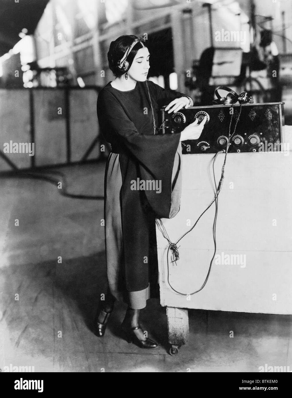 Nita Naldi (1897-1961), Italiano silent movie star meglio conosciuto per la riproduzione di una tomaia e come Rodolfo Valentino di co-star. Ella è in ascolto su una selezione operistico sul radiophone la California in un studio. 1922. Foto Stock