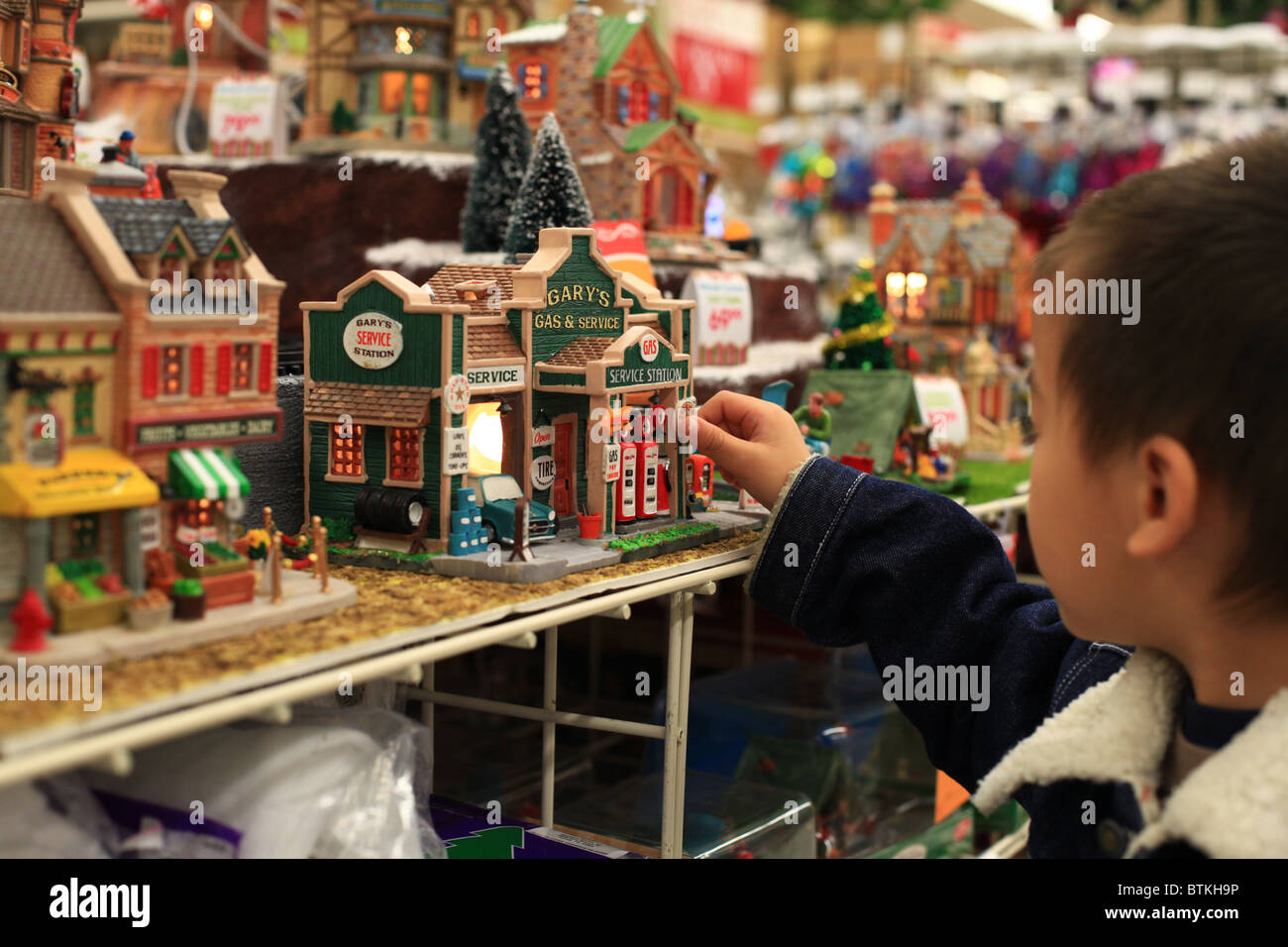 Un ragazzo giocando con la città in miniatura in un centro commerciale Foto Stock