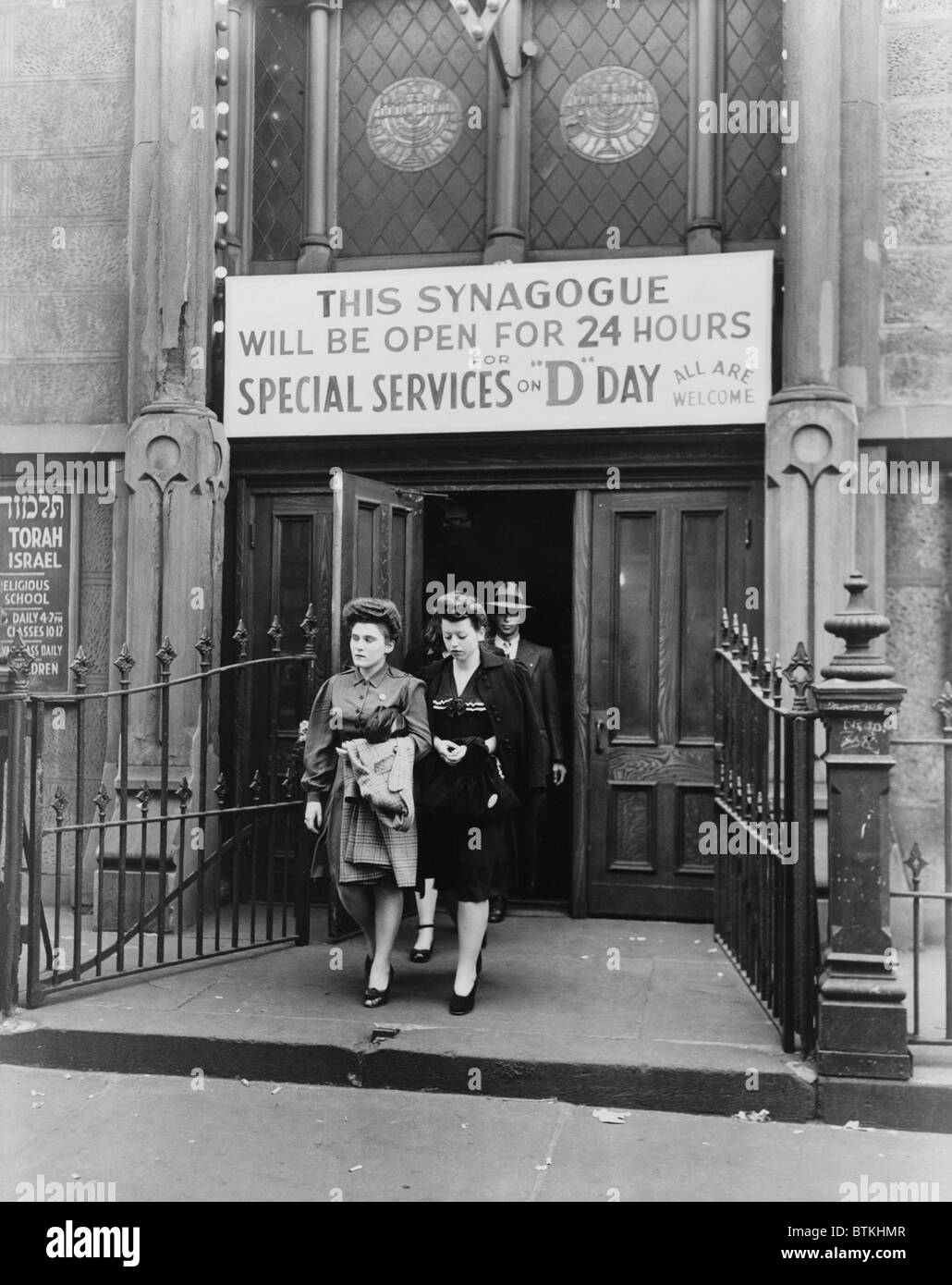 Le mogli e le famiglie di ebrei American GIs lasciare un New York City sinagoga sulla West ventitreesima Street, che è stato aperto tutto il giorno sul D-Day, Giugno 6, 1944. Essi si svegliò per l'annuncio che le truppe alleate sono state sbarcano sulle spiagge della Normandia e pregato per la sicurezza dei loro cari nel servizio militare. Foto Stock
