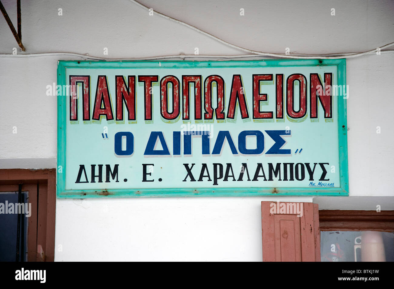 Negozio di greco segno sulla facciata di un magazzino generale in Parikia, sul Greco Cyclade isola di Paros. Foto Stock