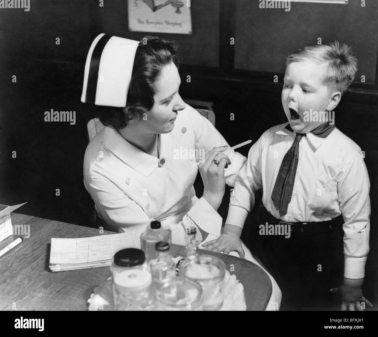 Un infermiere esaminando i denti di un ragazzo in New York, N.Y. , Ca. 1935. Foto Stock