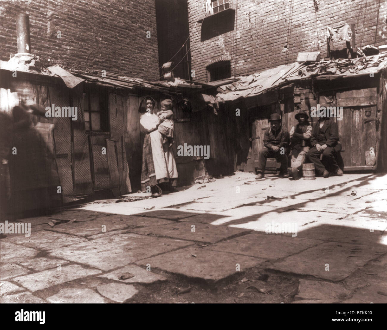 Cortile pavimentato con linee di latrine all'aperto in una delle città i peggiori slum su Jersey Street, dove poveri immigrati italiani vissuto a New York. 1889 foto di Jacob Riis. Foto Stock