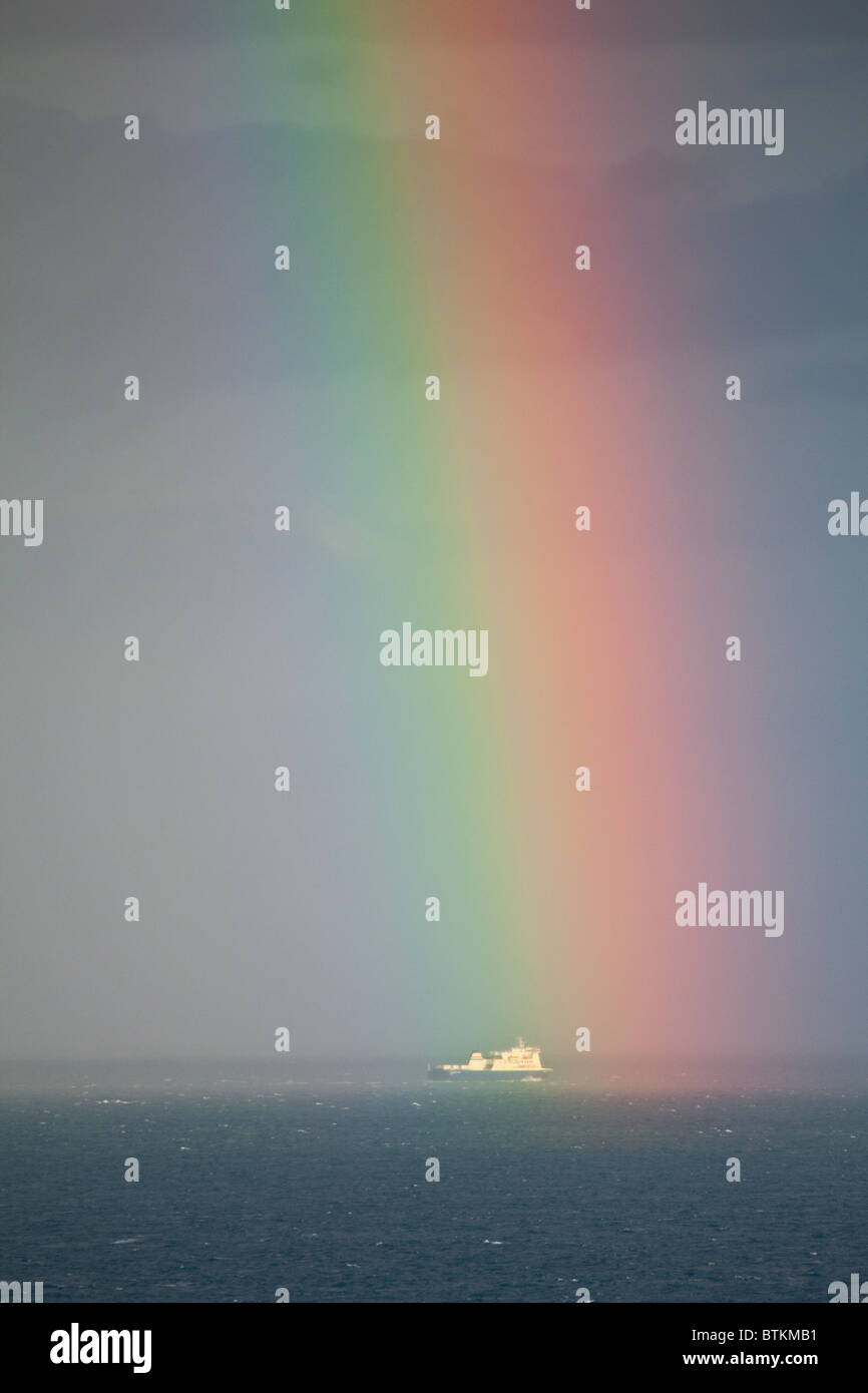 Un arcobaleno moduli sopra il Commodore Clipper sul suo modo di Jersey Foto Stock