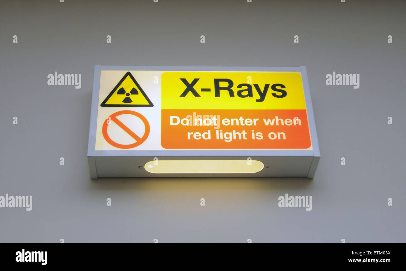 Un illuminato X-Ray segno di avvertimento sulla parete di una pratica dentistica Foto Stock