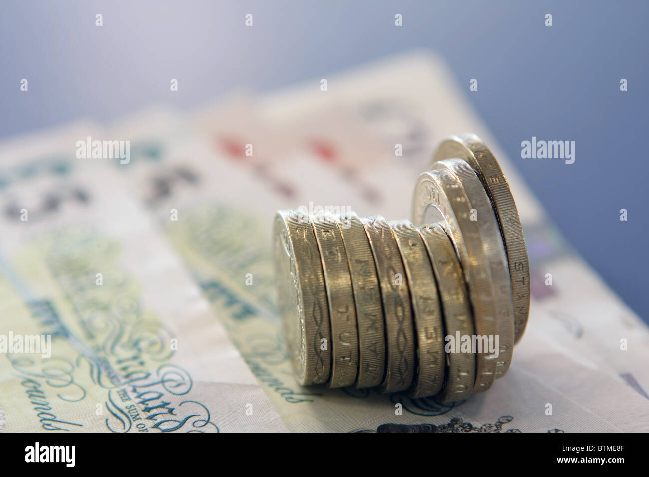Sterling £2 e £1 monete su più note di sterling Foto Stock