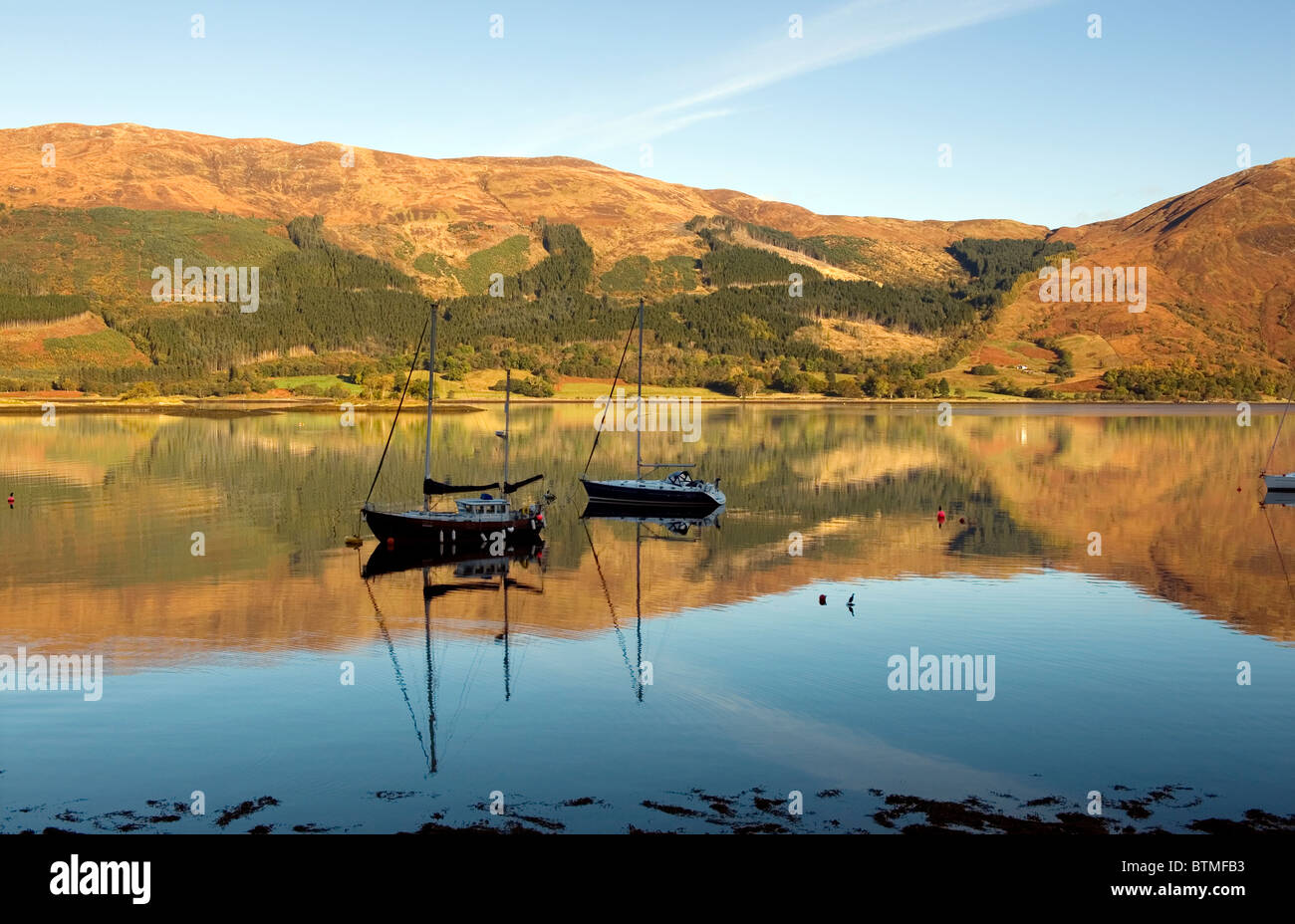 Loch Leven a sud di Ballachulish vicino a Glen Coe, Argyll, Scozia. Riflessioni perfetto nelle prime ore del mattino nitido luce. Foto Stock