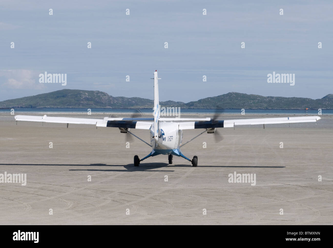 Un twin otter aeromobili uscire sulla spiaggia cockleshell a Barra pista di atterraggio per aerei, Ebridi Esterne, Scozia. SCO 6604 Foto Stock