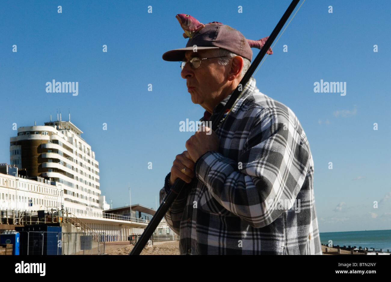 Maschi anziani pensionati uk hobby indossando un fascino fortunato la pesca hat . St Leonards on Sea East Sussex. Regno Unito HOMER SYKES Foto Stock