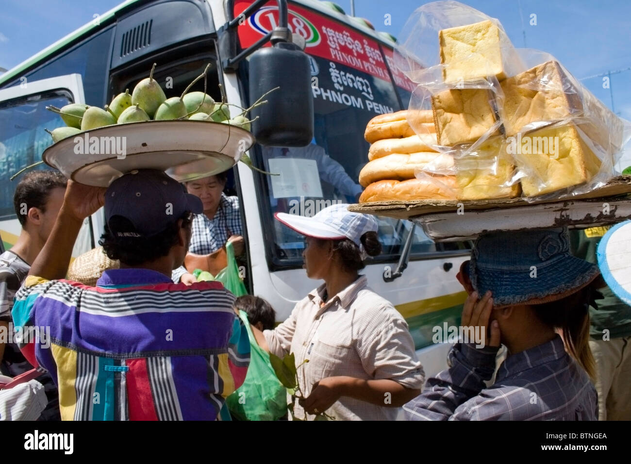 Venditori di prodotti alimentari sono di portare cibo sulle loro teste vicino Bavet, Cambogia. Foto Stock