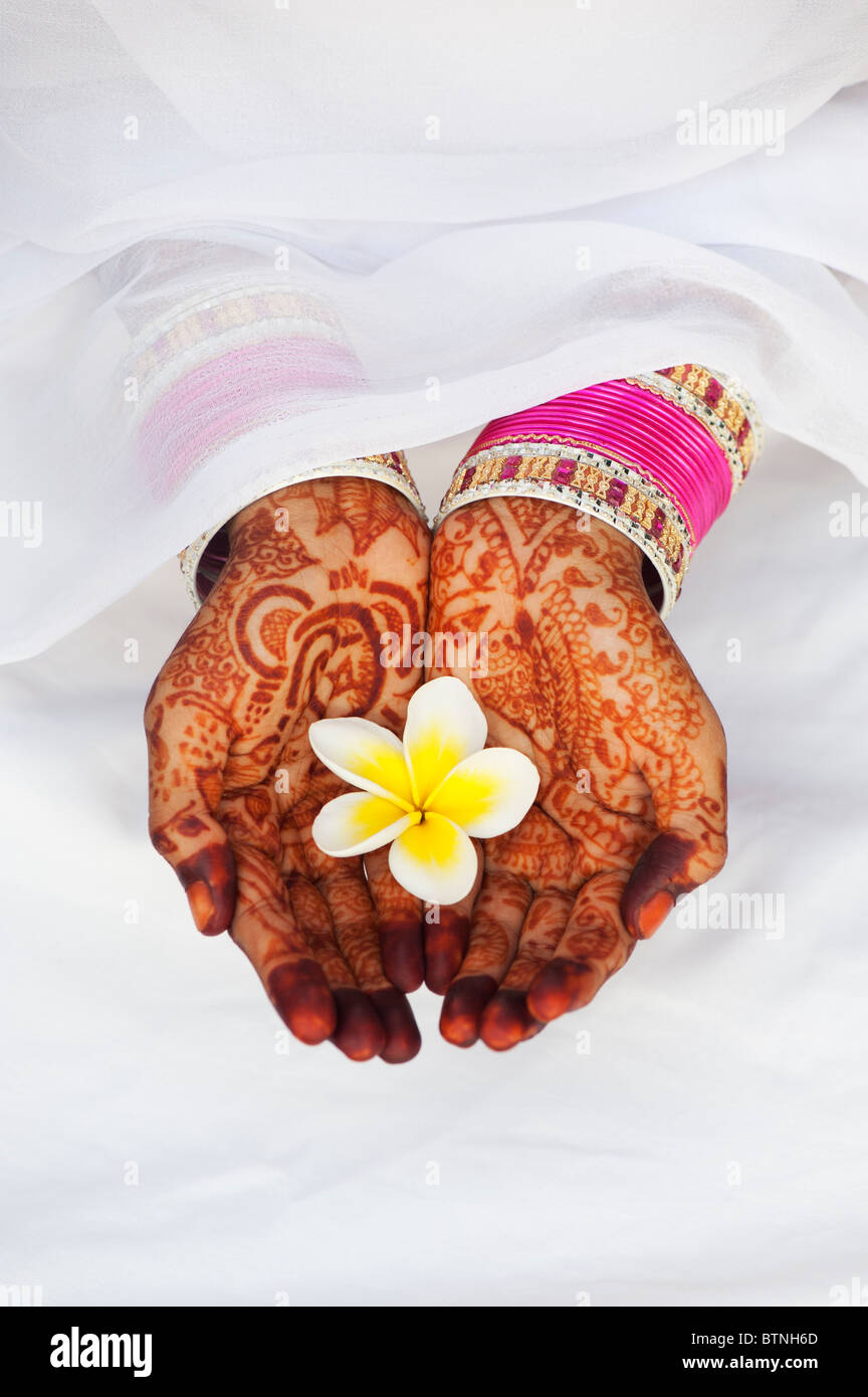 Ragazza indiana indossando sari con henné mani tenendo un fiore di frangipani. India Foto Stock