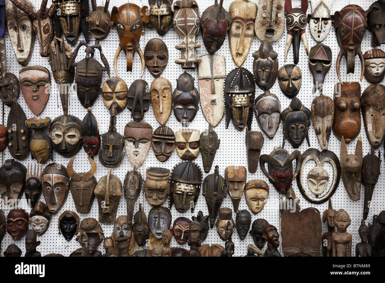 Le maschere africane sul display su un mercato in stallo Foto Stock