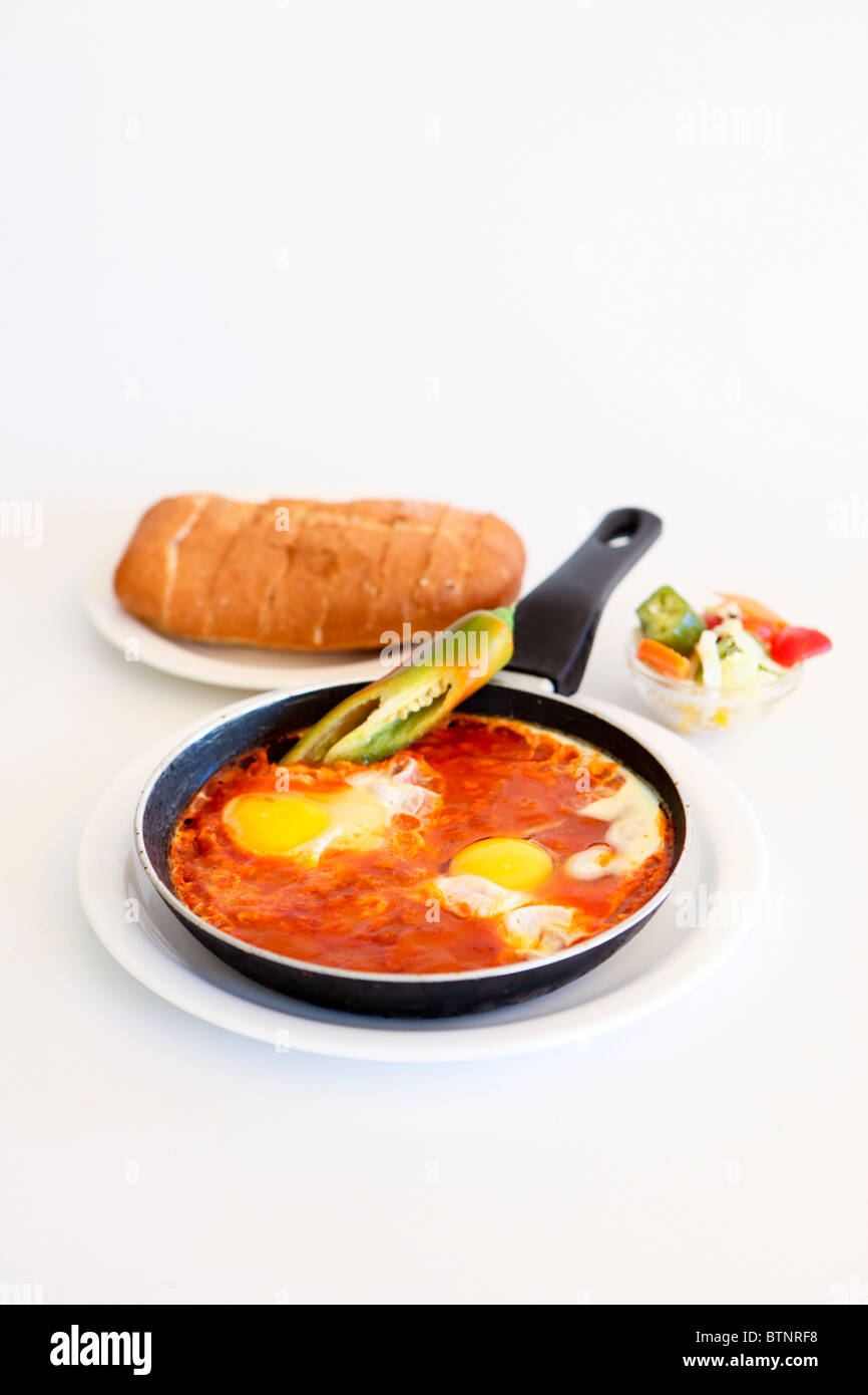 Shakshouka è un tunisino e israeliani di piatto a base di pomodori cotti, peperoni, spezie e uova. Foto Stock