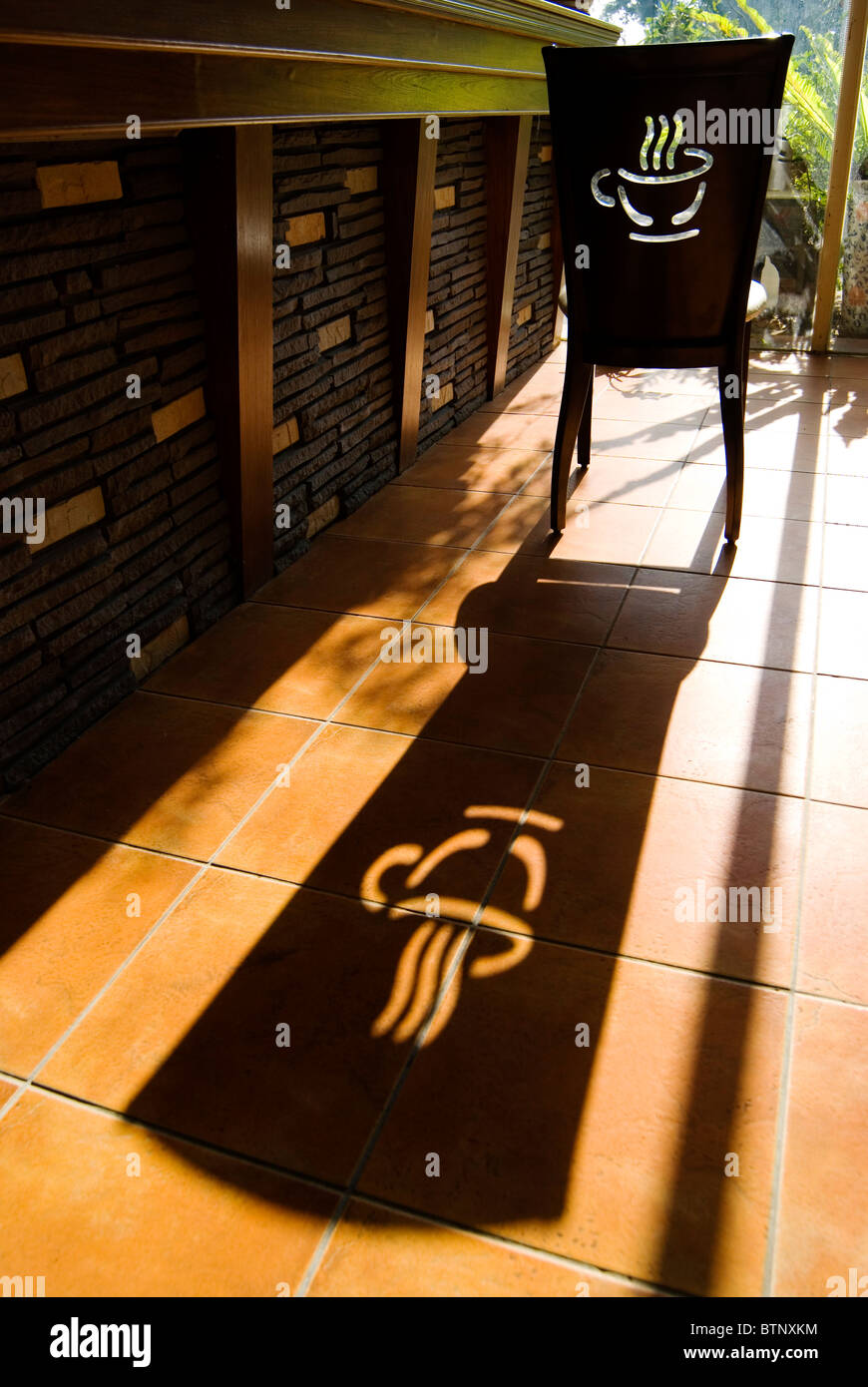 Sedia con logo di caffè e lunga ombra. È tempo per un caffè. Foto Stock