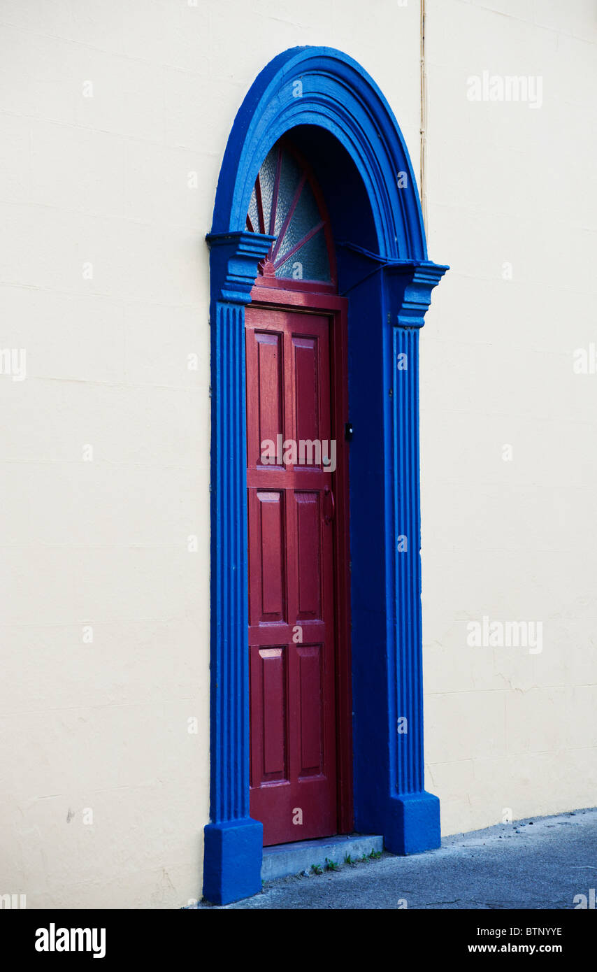 Una porta rossa in un blu del telaio della porta in una parete bianca a Siddal, vicino a Galway, Irlanda. Foto Stock