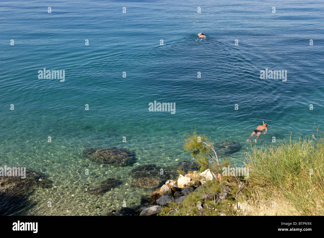 Persone fare snorkelling nelle acque limpide del mare Adriatico vicino alla città di Omis Croazia Foto Stock