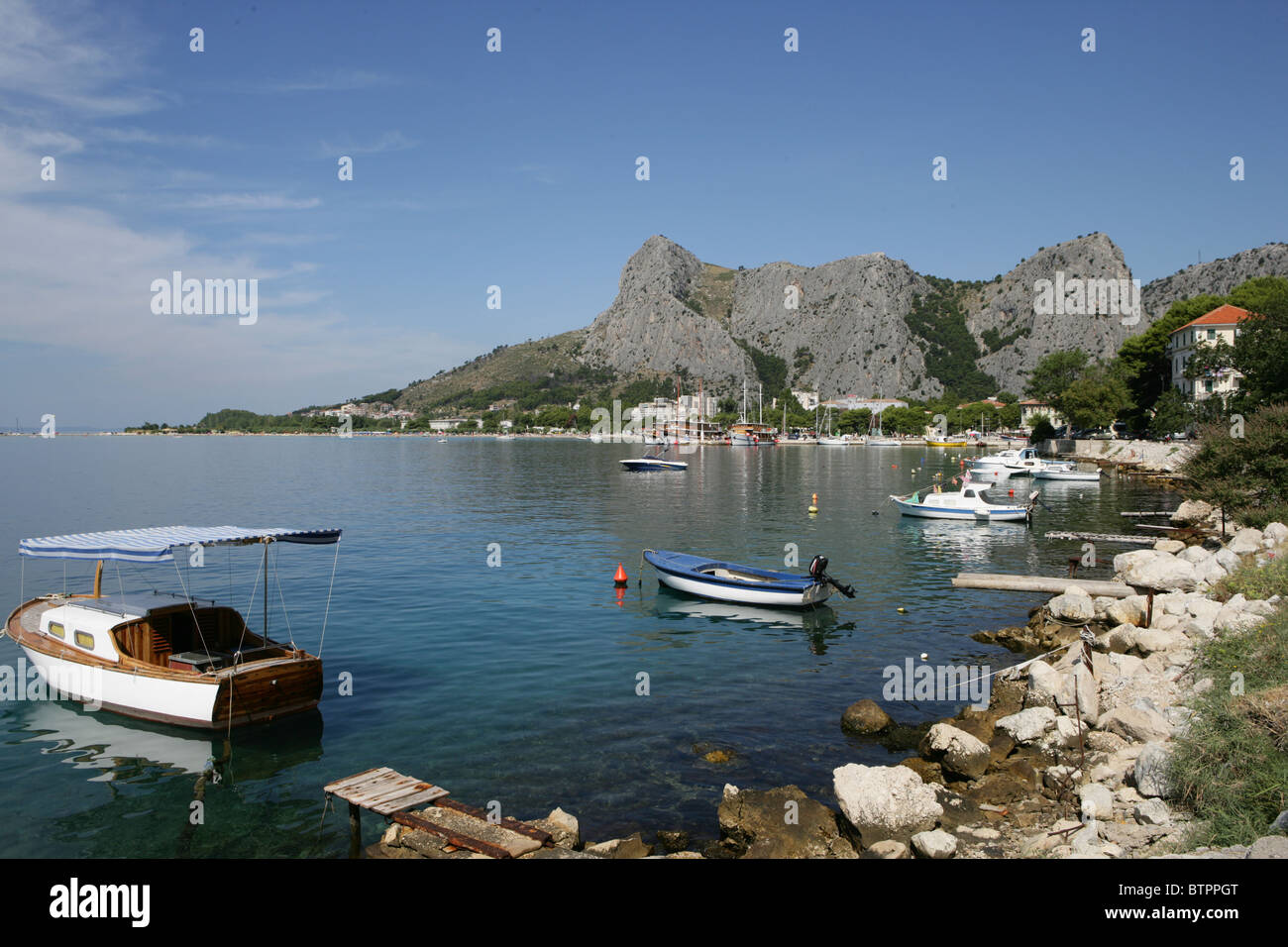 Una barca sulla spiaggia vicino alla città vecchia di Omis Croazia Foto Stock