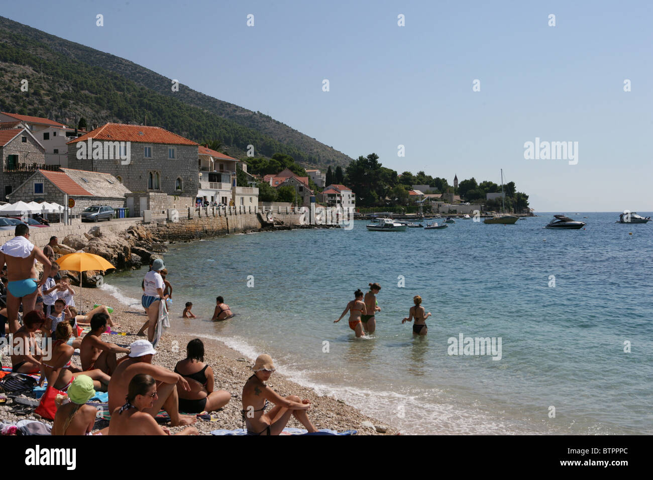 Persone giocare sulla spiaggia presso il porto di Bol sulla isola di Brac, Croazia Foto Stock