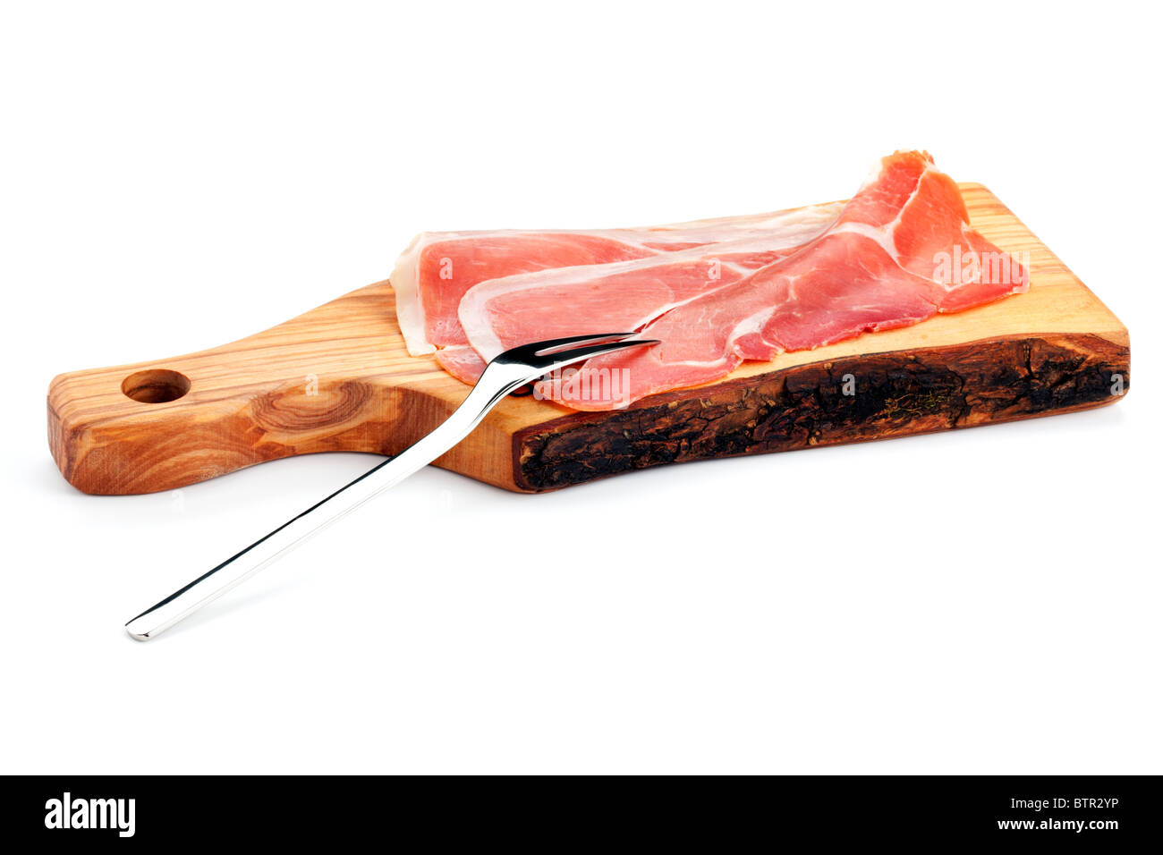 Tre fette di spagnolo dry-cured prosciutto Serrano su un tagliere di legno  con una forcella di carne Foto stock - Alamy