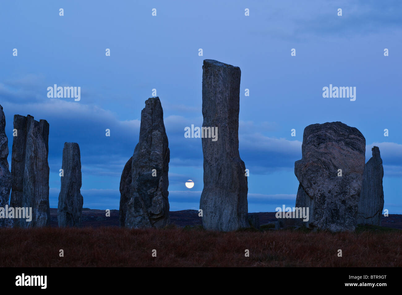 In autunno la luna piena sorge alle spalle di Callanish standing pietra, isola di Lewis, Ebridi Esterne, Scozia Foto Stock