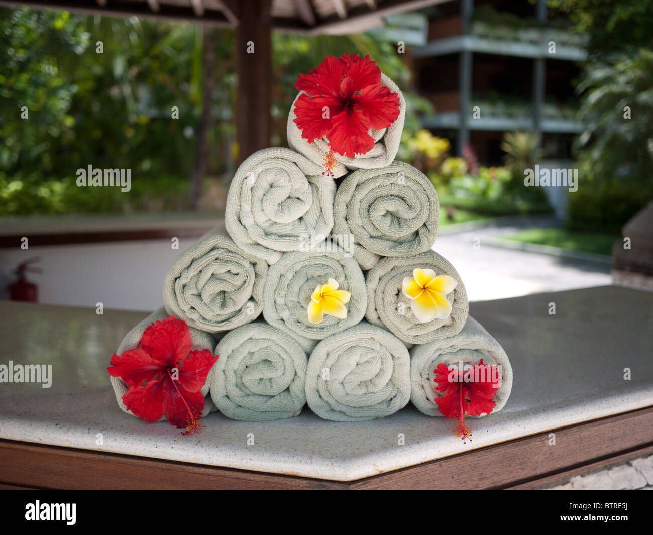 Asciugamani impilati nel triangolo ornato decorato con fiori in piscina al Melia Bali Hotel Bali Nusa Dua Indonesia Foto Stock