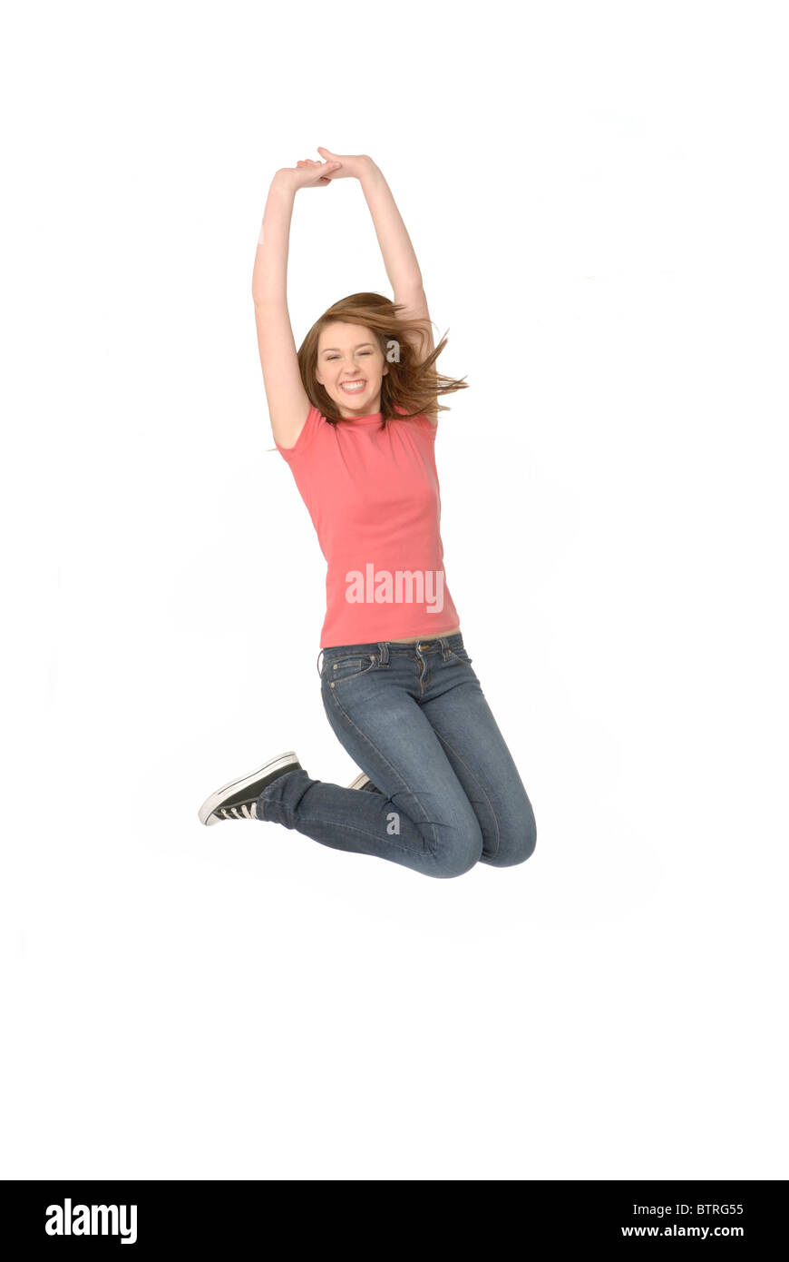 Felice ragazza adolescente di saltare in aria, su sfondo bianco. Foto Stock