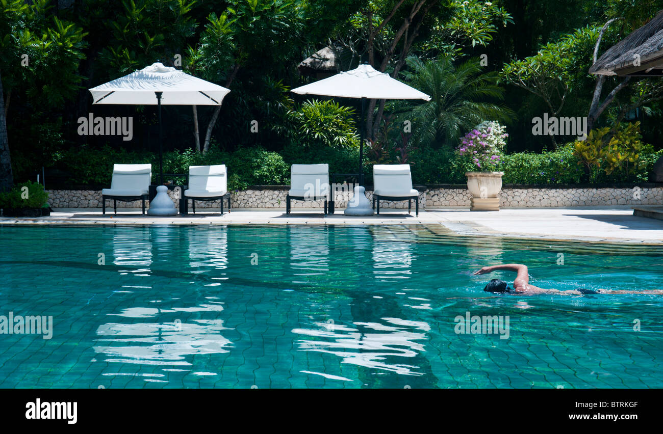 Piscina presso il Melia Bali Hotel, Nusa Dua Bali Indonesia con una persona di nuoto Foto Stock