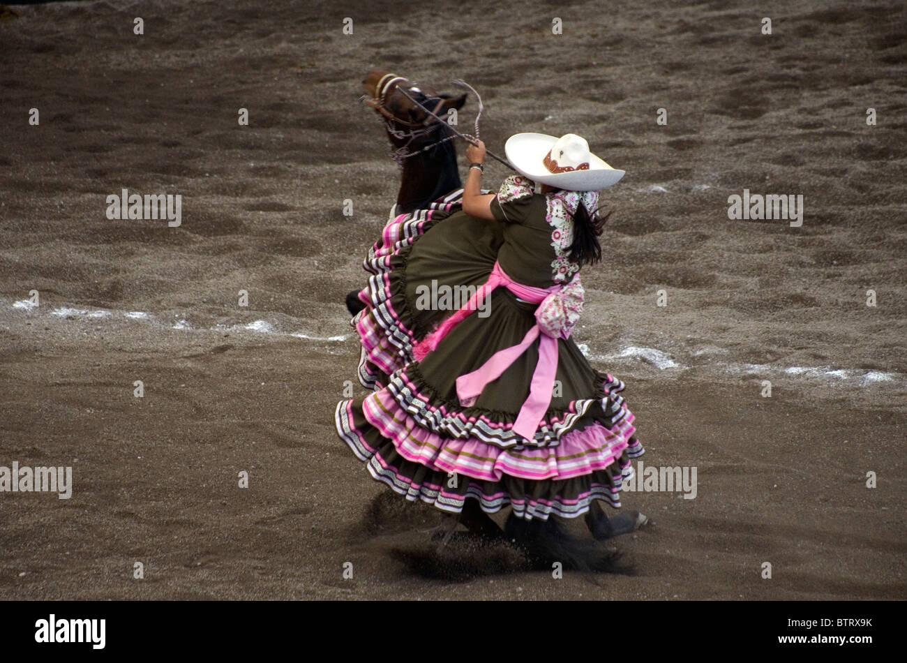 Un Amazona cavalca il suo cavallo a un concorso Escaramuza in città del Messico, 11 novembre 2010. Foto Stock