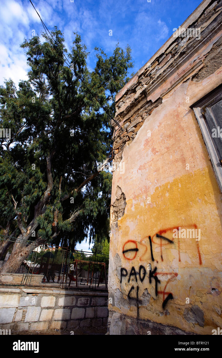 Sbriciolare facciata di un vecchio edificio contrassegnato con graffitis in Ermoupolis, sul Greco Cyclade isola di Syros. Foto Stock