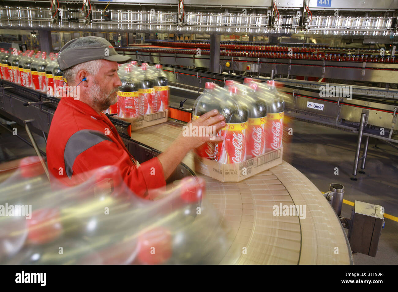 Lavoratore di Coca Cola fabbrica di imbottigliamento Foto Stock
