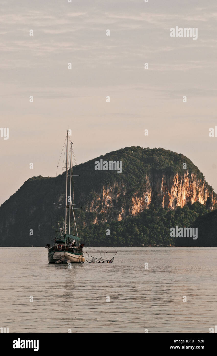 Una imbarcazione a vela ormeggiato a un'isola nel mare delle Andamane. Foto Stock