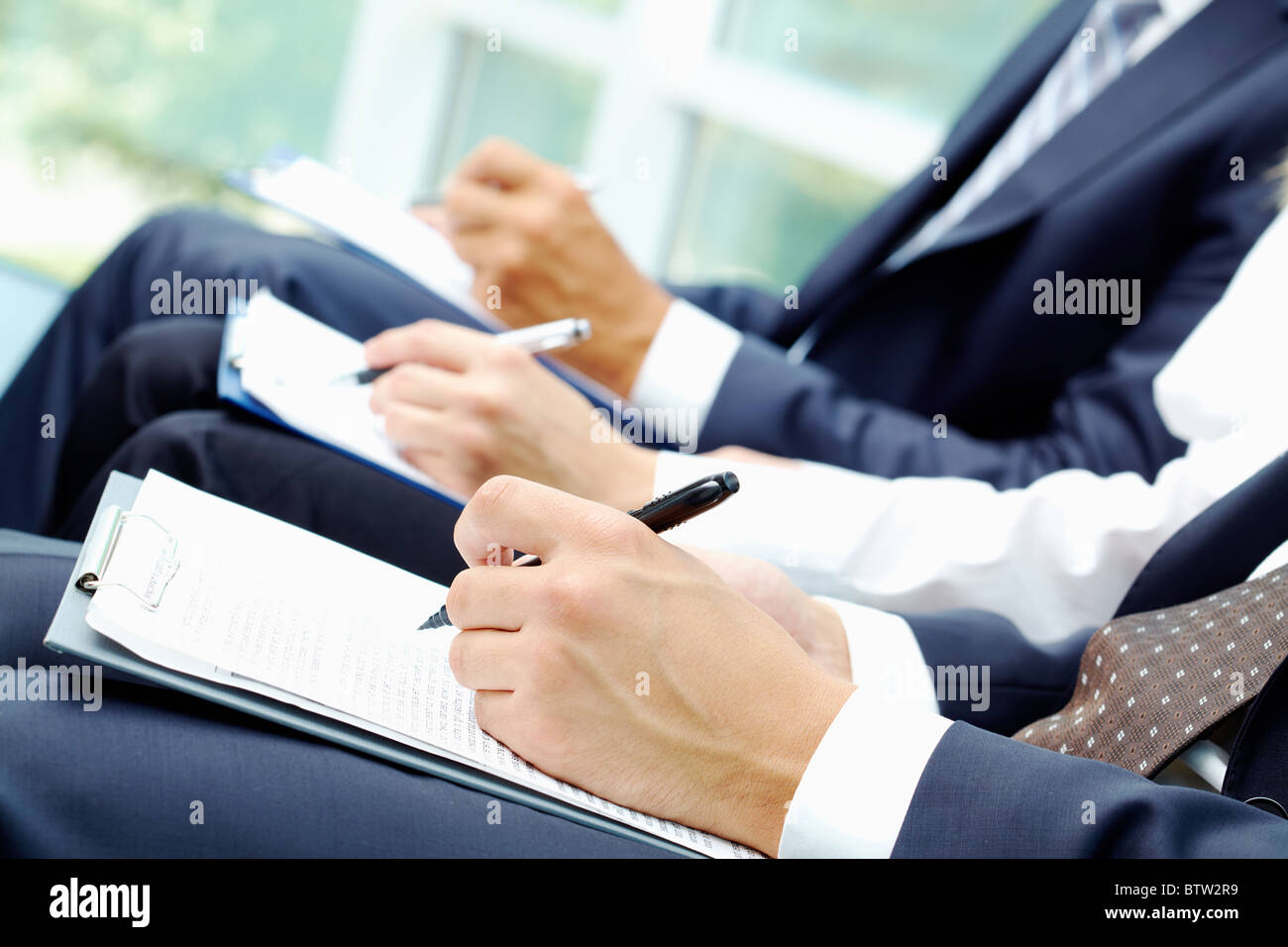 Close-up di gente di affari le mani con la scrittura del documento durante la conferenza Foto Stock