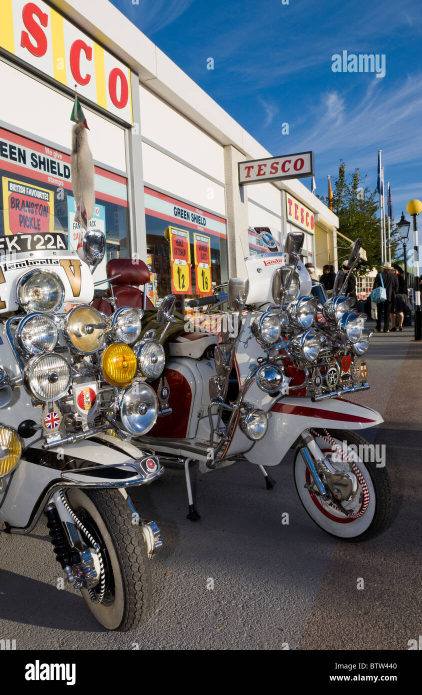 Scooters raccolte al di fuori di una simulazione degli anni sessanta il supermercato Tesco a 2010 Goodwood, Sussex, Inghilterra, Regno Unito. Foto Stock