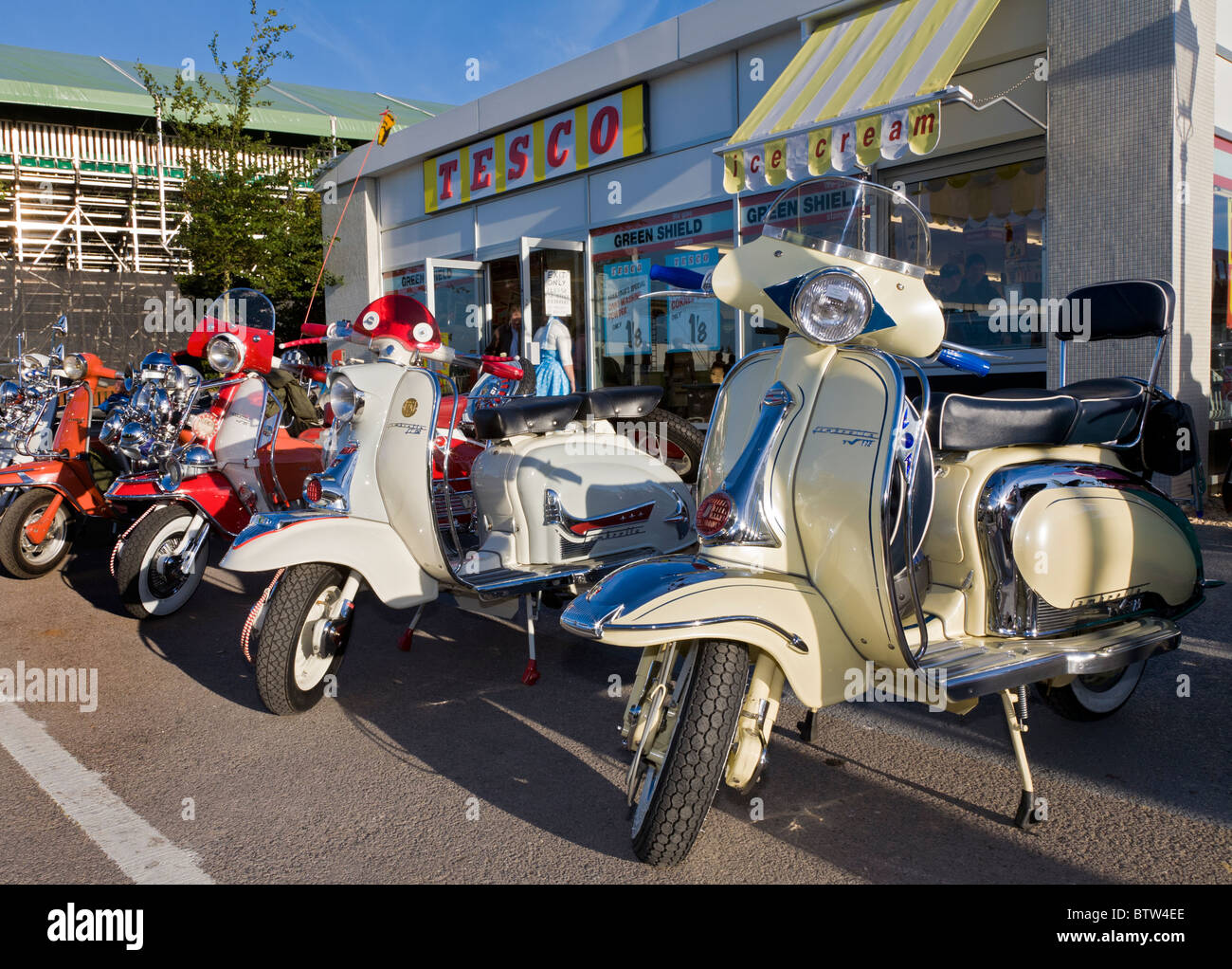 Scooters raccolte al di fuori di una simulazione degli anni sessanta il supermercato Tesco a 2010 Goodwood, Sussex, Inghilterra, Regno Unito. Foto Stock