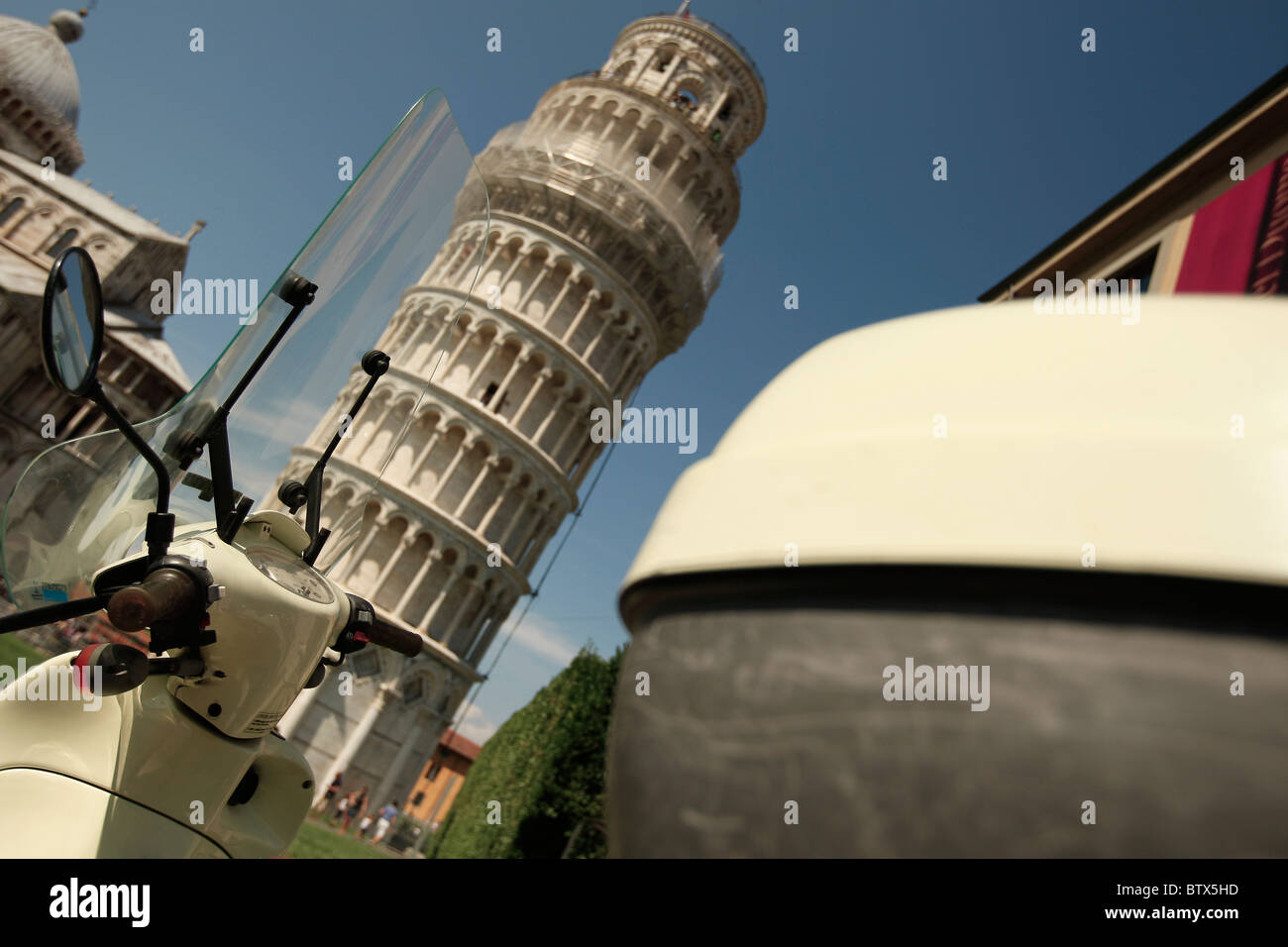 Scooter davanti a Pisa la torre pendente su un luminoso giorno di estate Foto Stock