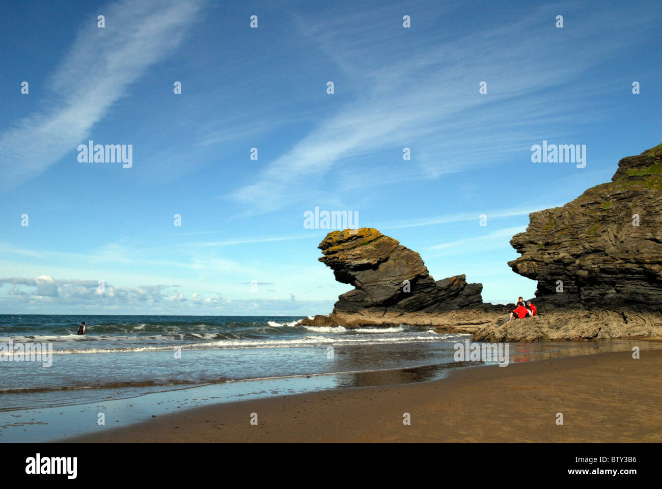 Ragazzi giocare sulle rocce e nel mare a Llangranog, West Wales Foto Stock