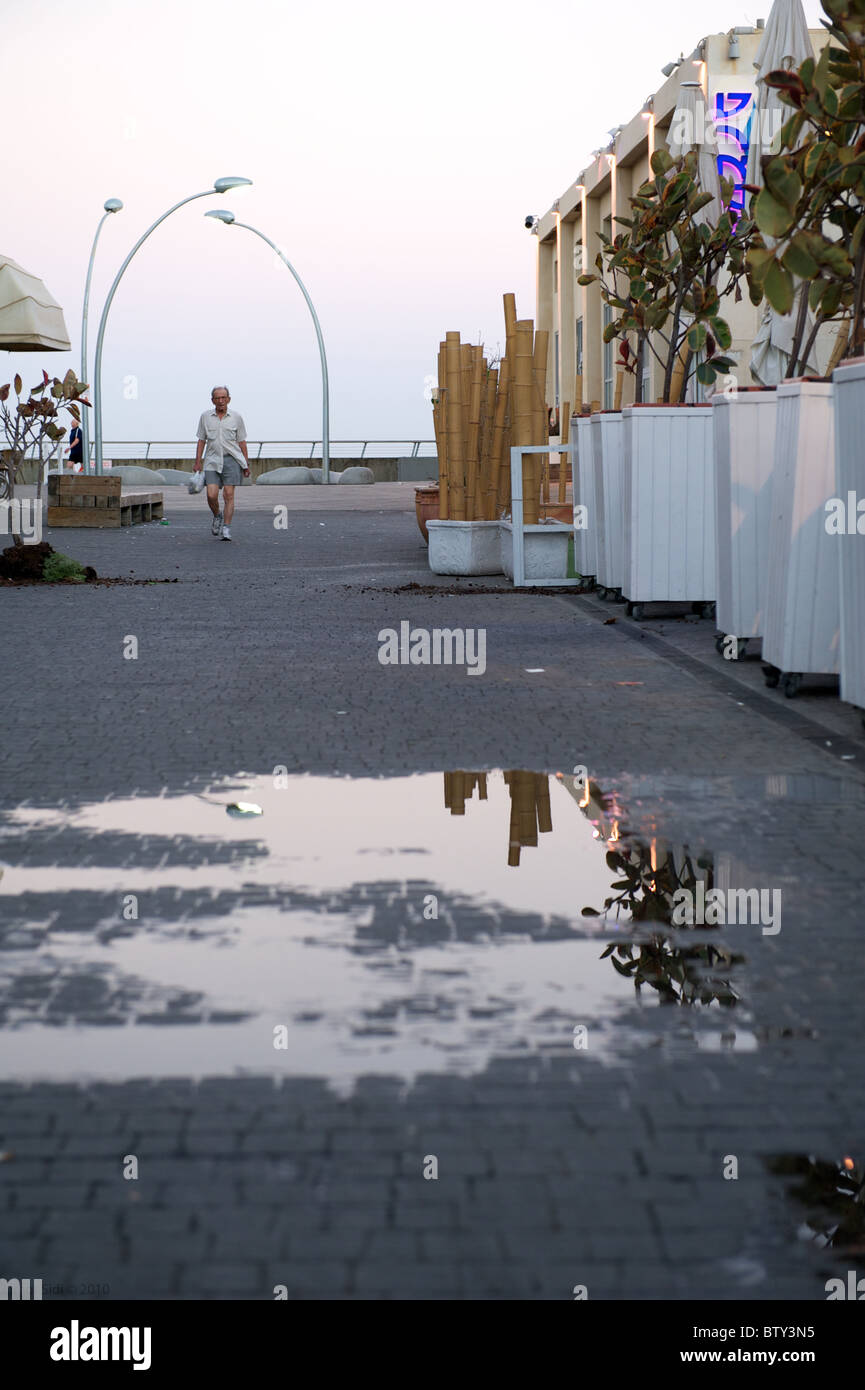 Un vecchio uomo che cammina al porto di Tel Aviv nelle prime ore del mattino Foto Stock
