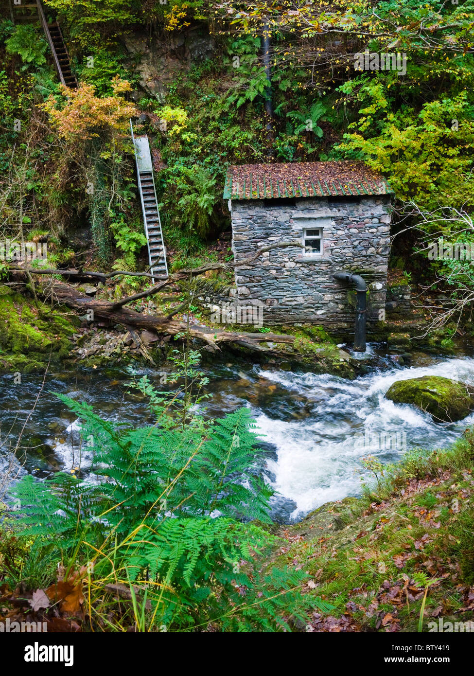 Una vecchia pompa a Colwith Force Waterfall sul fiume Brathay nel Lake District National Park vicino a Colcon, Cumbria, Inghilterra. Foto Stock
