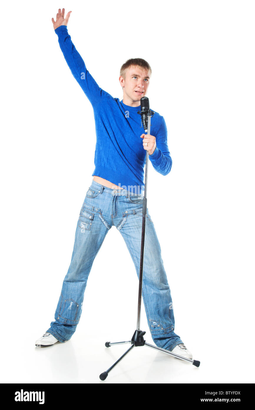 Un giovane uomo cantano in un microfono su sfondo bianco Foto Stock