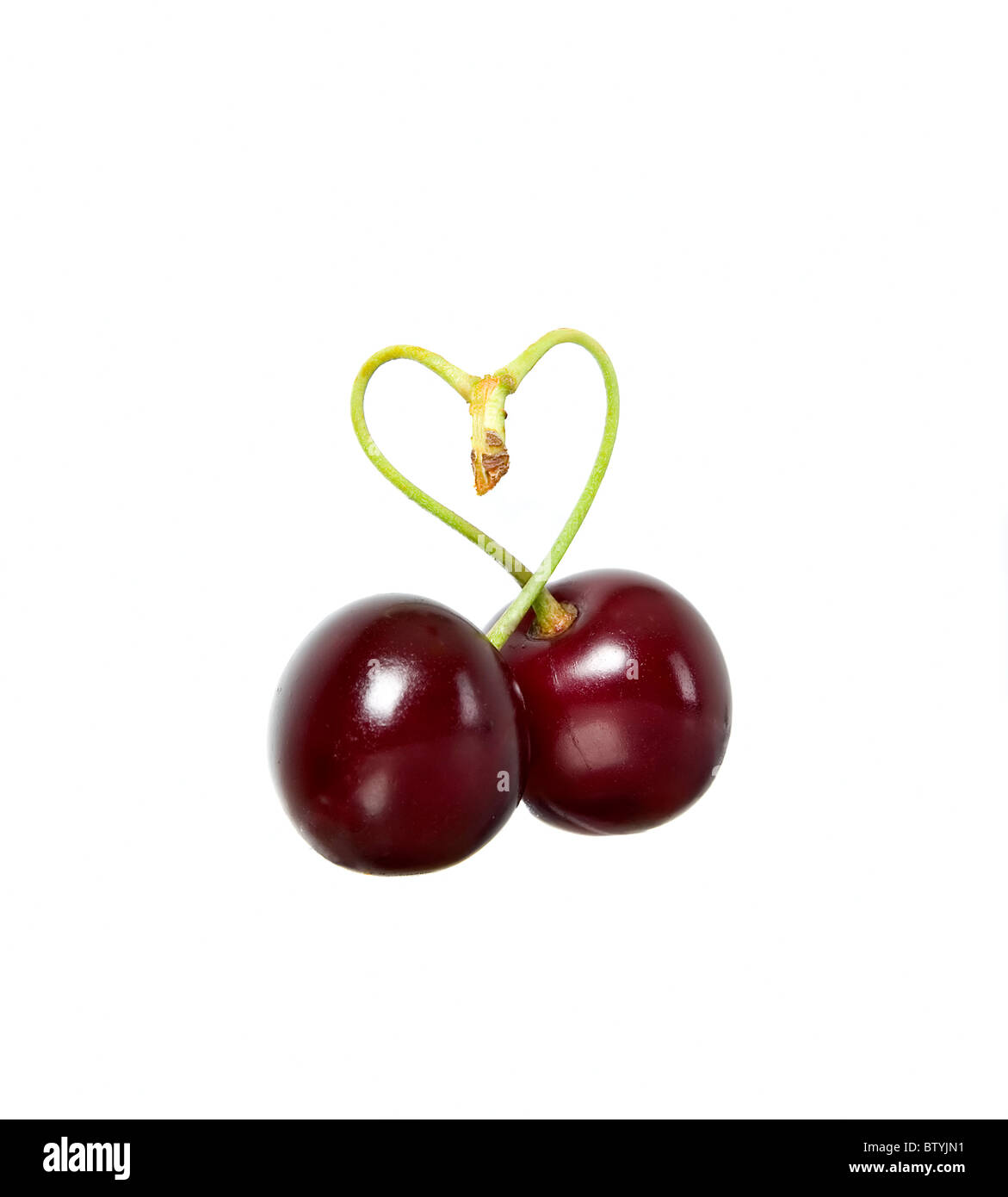 Due le ciliegie con piccioli come forma di cuore Foto Stock