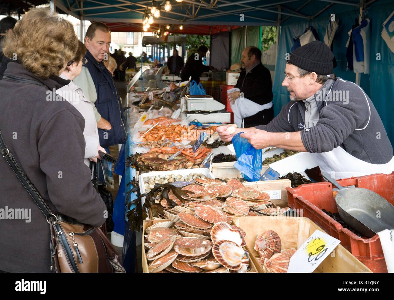 Un pescivendolo la vendita del pesce nel mercato francese delle città di Coulommiers, Ile de France Francia settentrionale Foto Stock