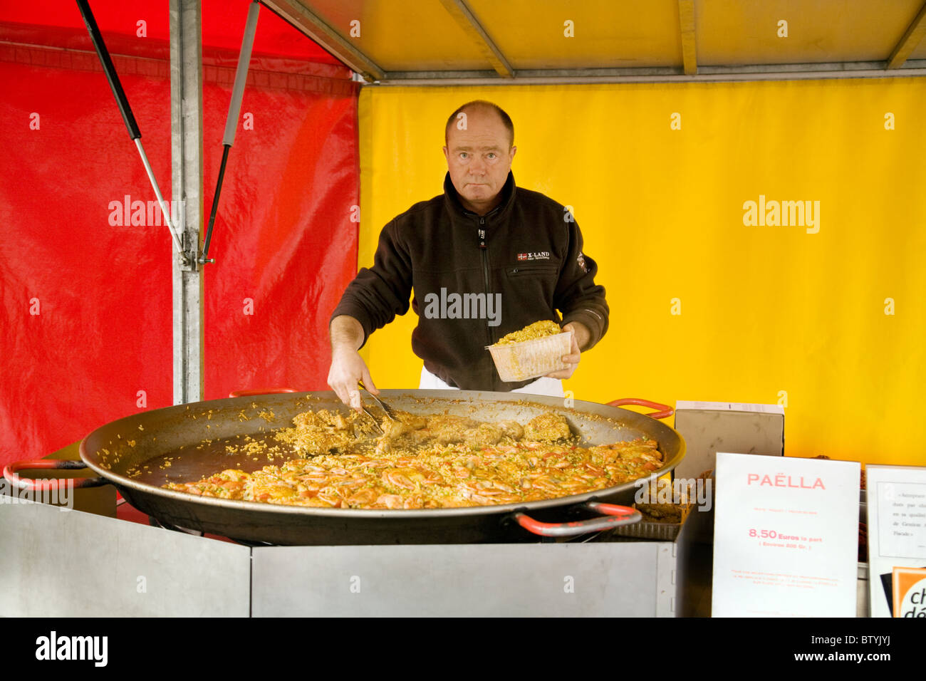 Un mercato di vendita stallkeeper paella nel tradizionale mercatino, la città di Coulommiers, Ile de France Francia settentrionale Foto Stock