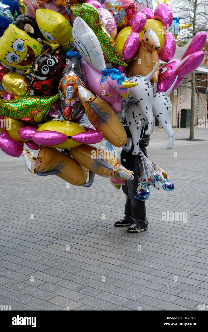 Venditore di palloncino oscurata dalla sua mercanzia. Foto Stock
