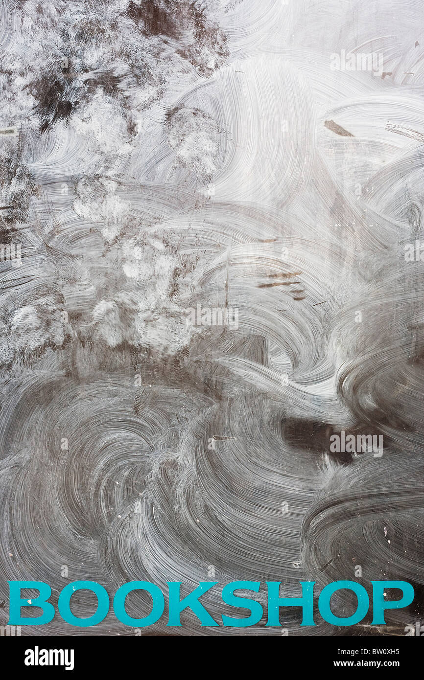 Emulsione bianca cosparsa di vernice oltre le parole CD e cassette nella finestra di un ex cristiano CD, libri e negozio di software. Foto Stock