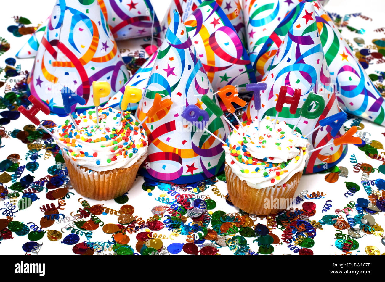 Festa di compleanno con tortine, candele, cappelli e coriandoli. Foto Stock